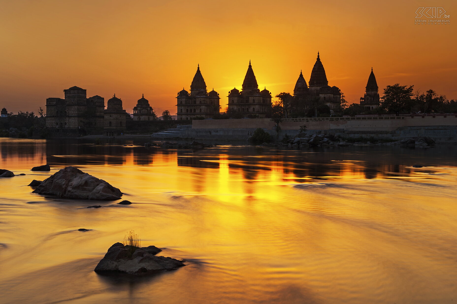 Orchha - Zonsondergang Betwa rivier Zonsondergang aan de oevers van de Betwa rivier in Orchha (Madhya Pradesh) met de mooie Chhatris aan de andere kant. Deze Chhatris zijn de graven van de Maharadja's en ze werden gebouwd in de 15e eeuw. Ik gebruikte mijn ND filter om een betere spiegeling van de Chhatris in het water te verkrijgen. Stefan Cruysberghs